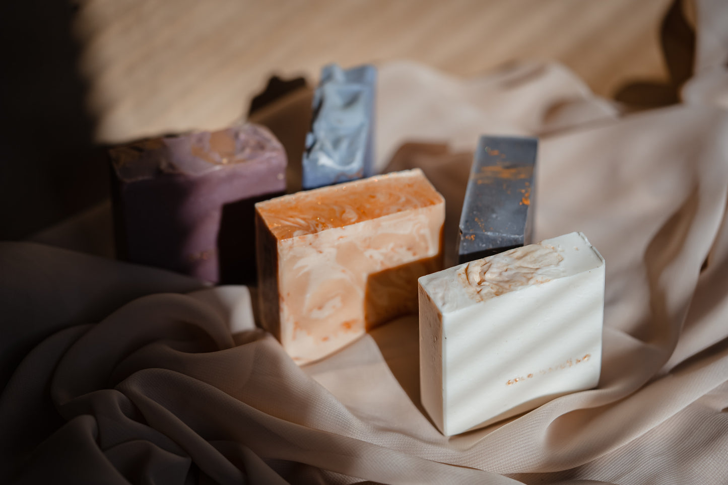 Assorted bars of soap on a textured fabric surface